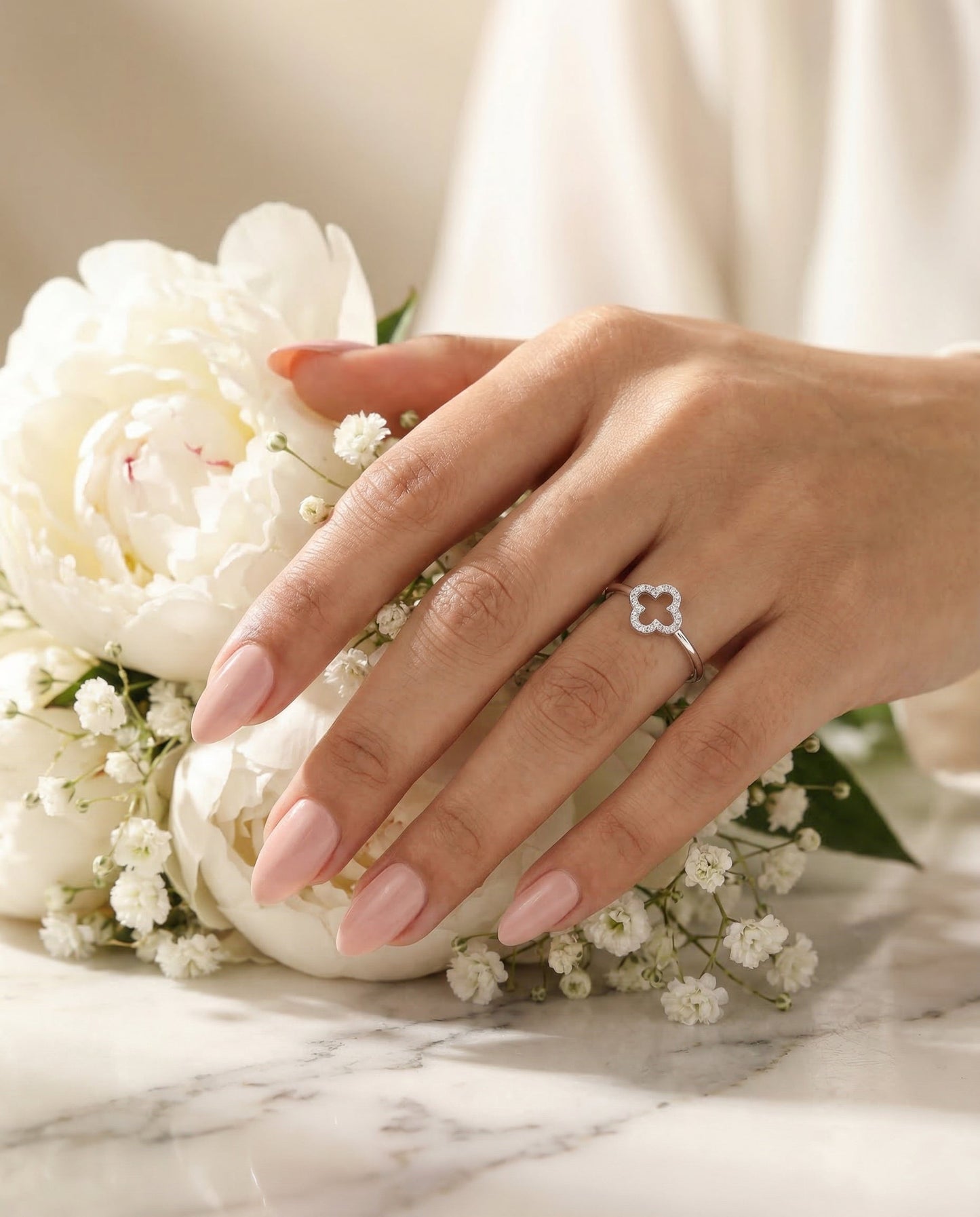 Clover Ring — Hand on white peony bouquet, ultra-thin band