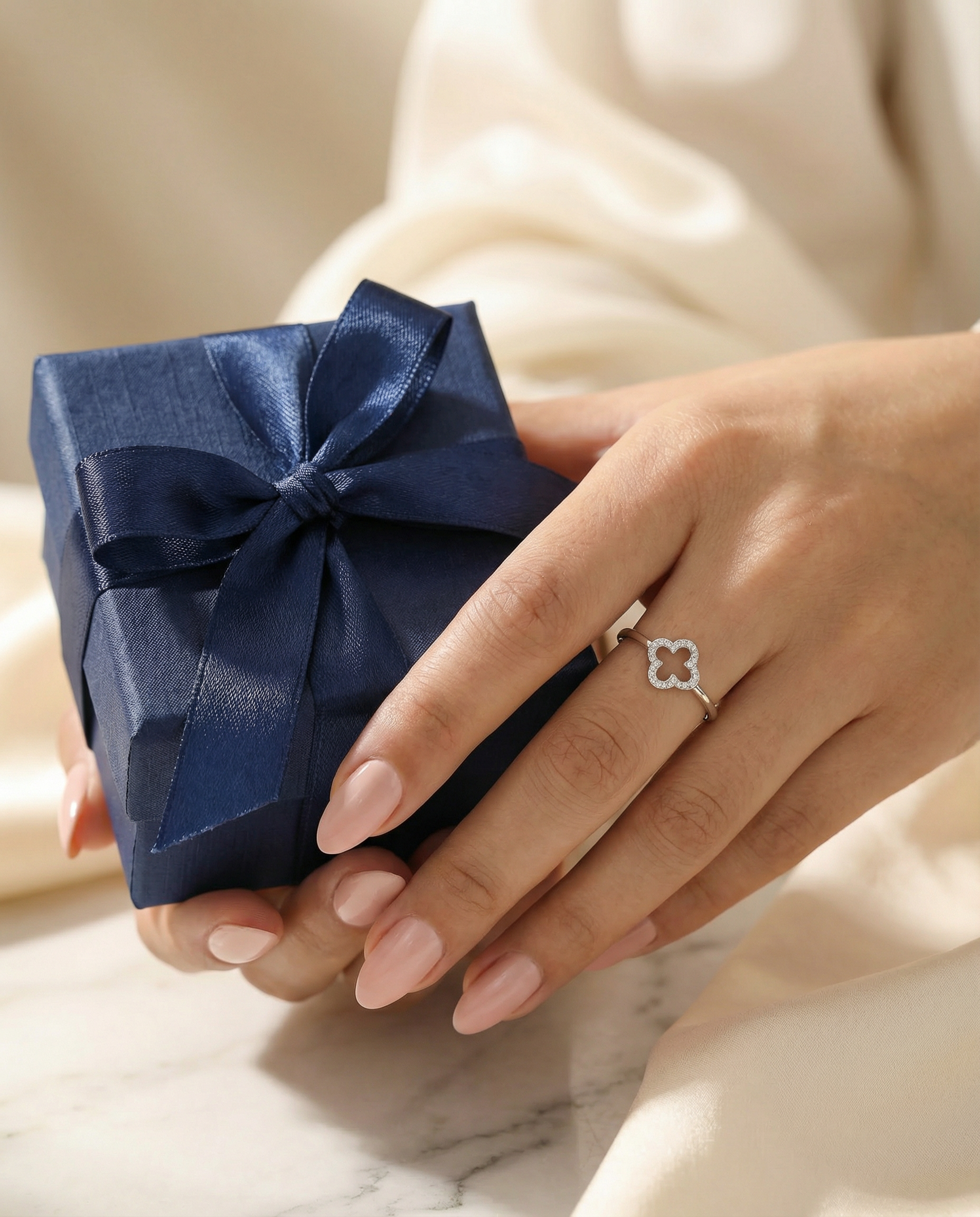 Clover Ring — Hand holding a navy blue gift box, gift concept